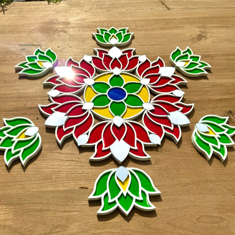 A colorful handcrafted rangoli design on a wooden surface, decorated with vibrant red, green, and yellow patterns, with additional small green and red shapes around it.